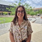 Ellie Robinson wears glasses and smiles at the camera